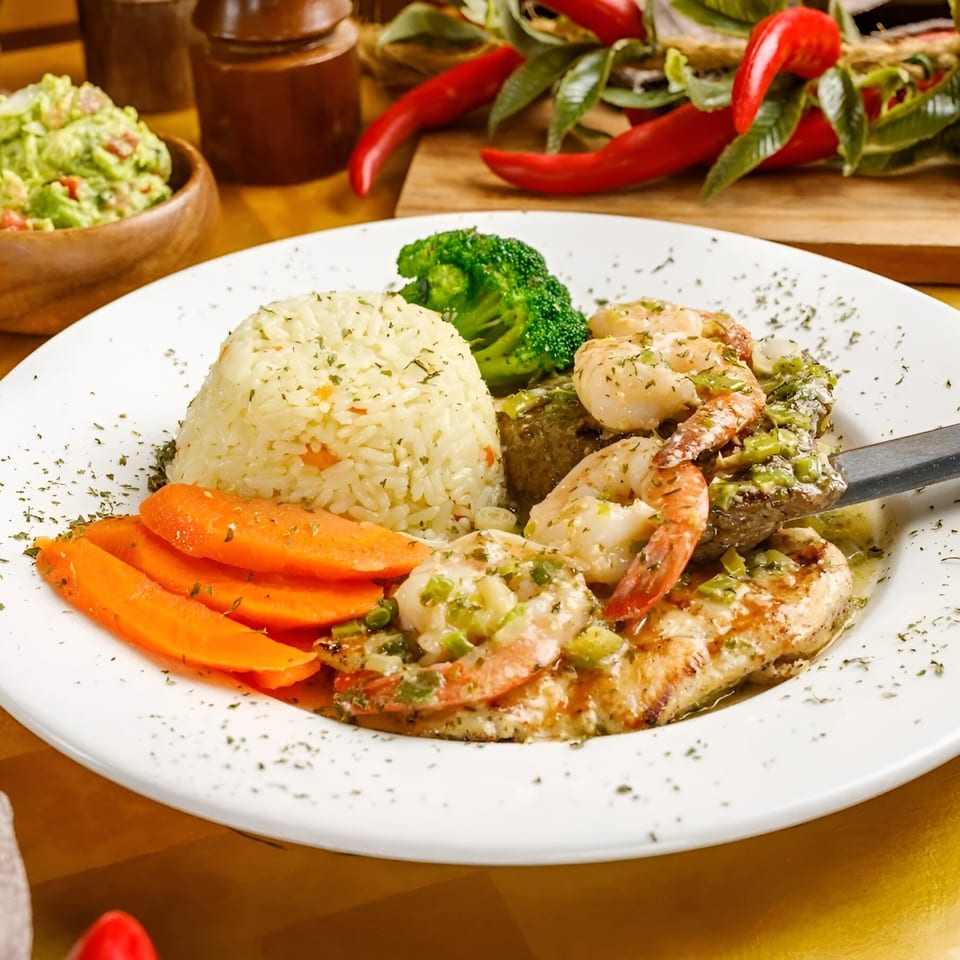 Delicia's Salvadoran dish with rice, shrimp, carrots, and broccoli, garnished with herbs.