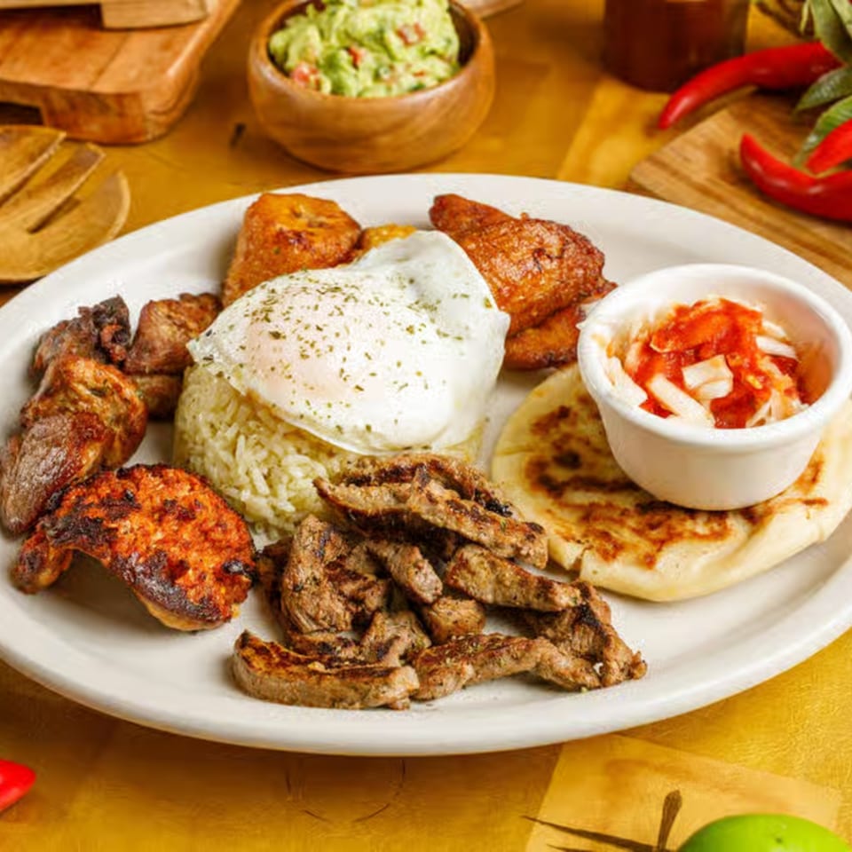 Delicia's Salvadoran breakfast with fried egg, rice, plantains, grilled meats, pupusa, and curtido.
